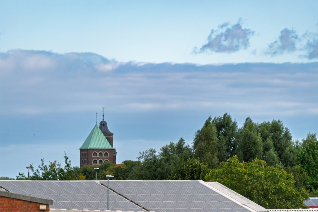 Church tower with green roof amongst trees